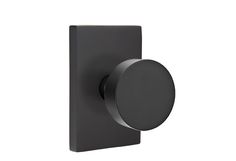 an image of a black square knob on a white wall with grey trim and round button