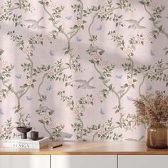 the wallpaper is decorated with birds and flowers in pastel colors, along with books