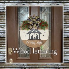 a christmas door hanger with a nativity scene on it and the words, wood lettering