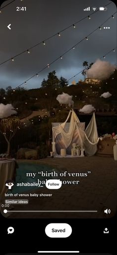 an iphone screen with the text, my birth of venus above it and some lights strung overhead