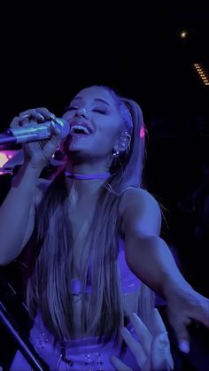 a woman singing into a microphone at a concert