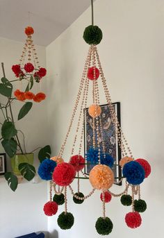 a chandelier hanging from the ceiling with pom - poms on it