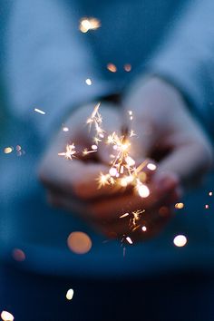 a person holding sparklers in their hands with the words las estrellas brilliant para todos