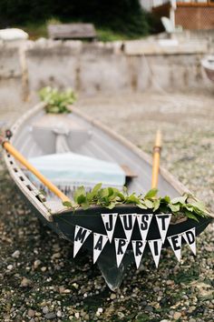 a row boat with plants in it sitting on gravel