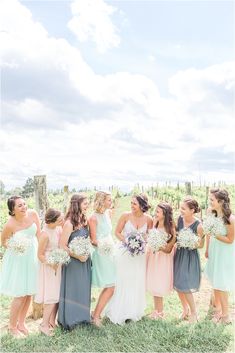 a group of women standing next to each other on top of a grass covered field