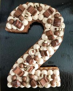 the number two made out of chocolate and marshmallows on a black surface