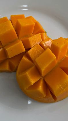 two pieces of mango sitting on top of a white plate