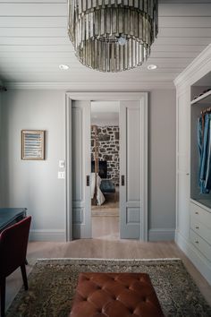 a living room with a chandelier hanging from the ceiling next to a bed