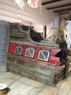 an old wooden boat sitting in a garage