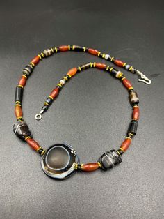 The beautiful contemporary beads necklace consist of ancient agate and carnelian beads along with big round banded agate Lukmik magic eye bead in the center of the necklace with two more special beads , elephant figure carved beads in black and white banded agate in the sides of the necklace as you can see in the above pictures the origin of this beads from south east Asian countries some black color glass beads and some gold color brass beads are used as spacers in the necklace we provide fast Unique Carnelian Jewelry With Colorful Beads, Unique Carnelian Necklaces, Carnelian Amulet Jewelry With Round Beads, Amulet Style Round Beaded Necklace With Large Beads, Artisan Agate Beaded Round Necklaces, Amulet Style Beaded Necklace With Gemstone Beads, Gemstone Beads Amulet Necklace, Amulet Style Round Gemstone Beaded Necklaces, Unique Agate Beads