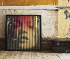 an image of a woman's face on the wall next to some suitcases