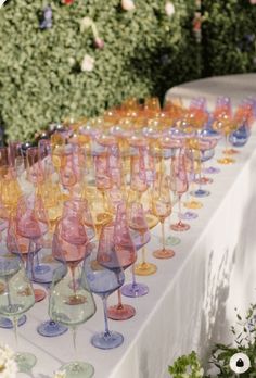 many wine glasses are lined up on a table