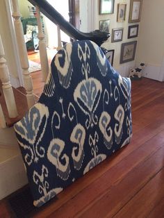 a blue and white chair sitting on top of a wooden floor next to a stair case