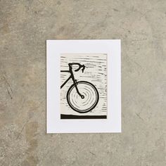 a black and white drawing of a bicycle on a concrete surface with the word bike written below it