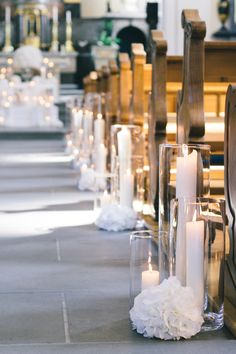 rows of pews with candles and flowers on the floor in front of them at a church