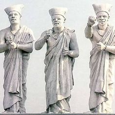 three statues of men standing next to each other