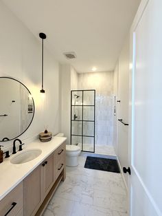 a bathroom with two sinks, a toilet and a shower