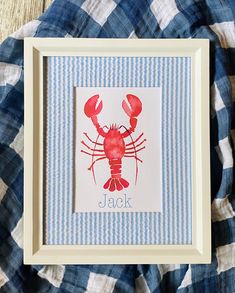 a red lobster is in a white frame on a blue and white checkered blanket