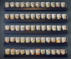 coffee mugs are lined up on the wall