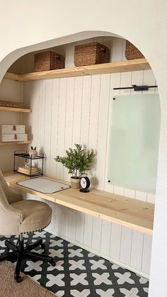 an office with a desk, chair and shelves on the wall above it is also a potted plant