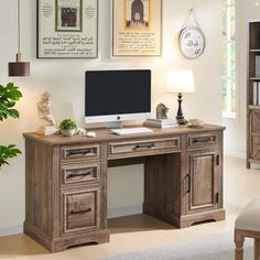 a desk with a computer on top of it in front of a bookcase and chair