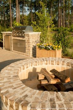 an outdoor bbq with fire pit and grill in the middle