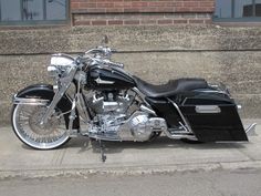 a black and silver motorcycle parked on the side of a street next to some stairs