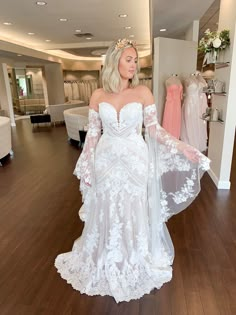 a woman in a white wedding dress standing on a hard wood floor