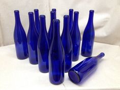 blue glass bottles lined up on a white surface