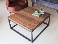 a wooden table sitting on top of a hard wood floor next to a blue couch