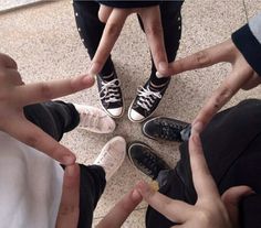 four people standing in a circle with their hands together