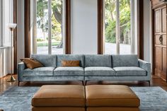 a living room filled with furniture and large windows