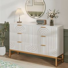 a living room with a white dresser and a round mirror