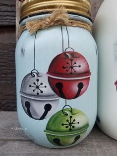 two painted mason jars sitting next to each other