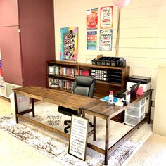 a wooden table sitting on top of a carpeted floor next to a book shelf