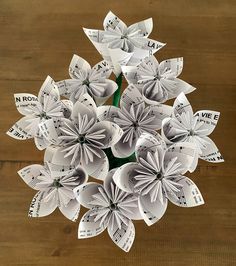 a bouquet of paper flowers on top of a wooden table with music notes attached to them