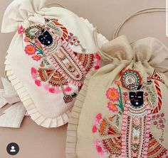 two bags with embroidered designs on them are sitting next to each other and one has a drawstring bag in the shape of an elephant