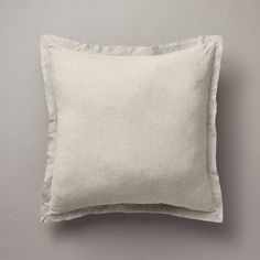 a white pillow sitting on top of a gray wall