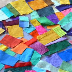 a pile of colorful pieces of cloth sitting on top of a table