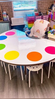 a large table with multicolored polka dots on it in a room filled with furniture