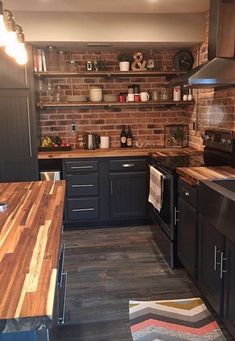 a kitchen with black cabinets and wooden counter tops