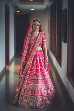 a woman in a pink and gold bridal outfit