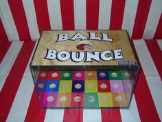 a box that is sitting on top of a striped table cloth with the word ball bounce in it