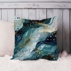 a blue and gold pillow sitting on top of a white furnishing covered bed