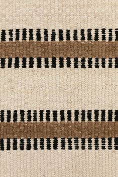 an area rug with black and brown stripes on it's side, in neutral colors