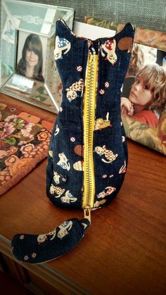 a small purse sitting on top of a wooden table next to a framed photo and other items