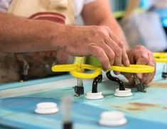 a man is working on some type of device with yellow handles and black wires attached to it