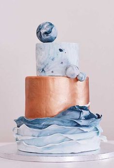 a three tiered cake with blue and gold icing