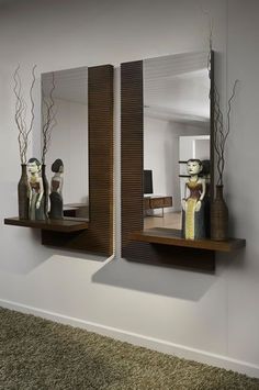 two mirrors on the wall with vases in them