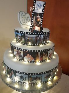 a three tiered cake decorated with pictures and lights